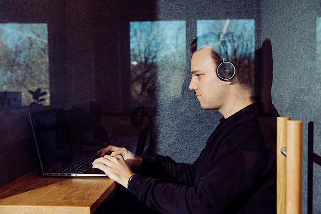 Manuel telefoniert in einer Telefonbox über seinen Laptop.